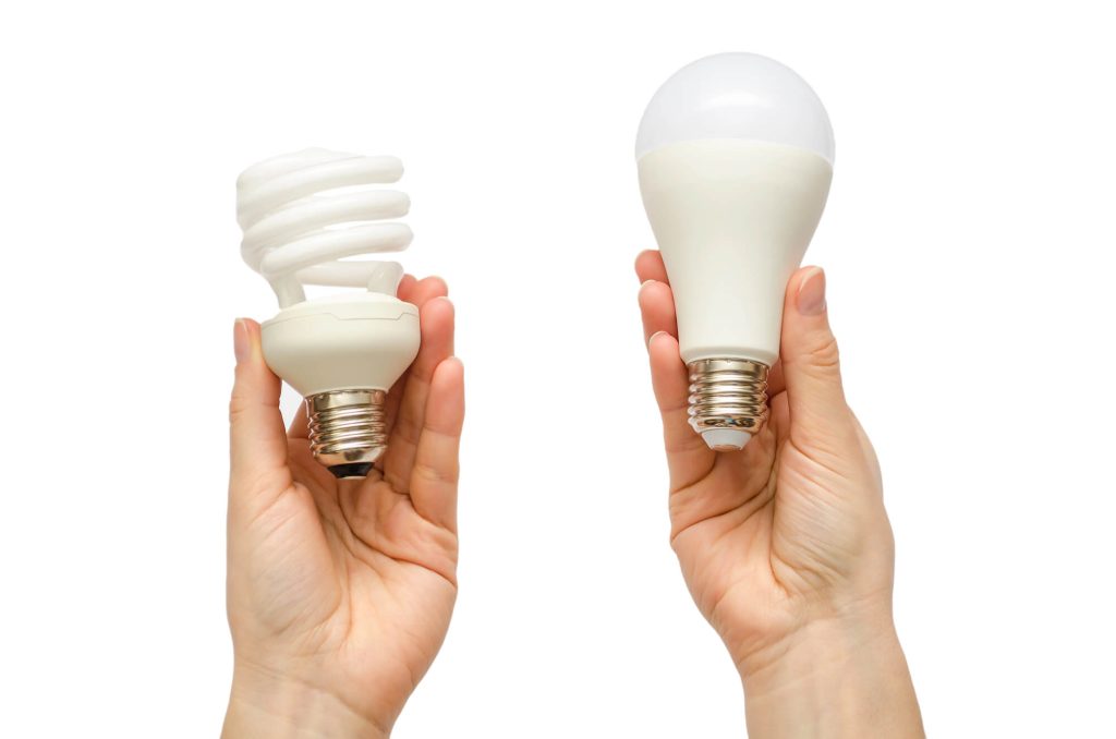 LED vs Flourescent Lightbulbs Held in Hands