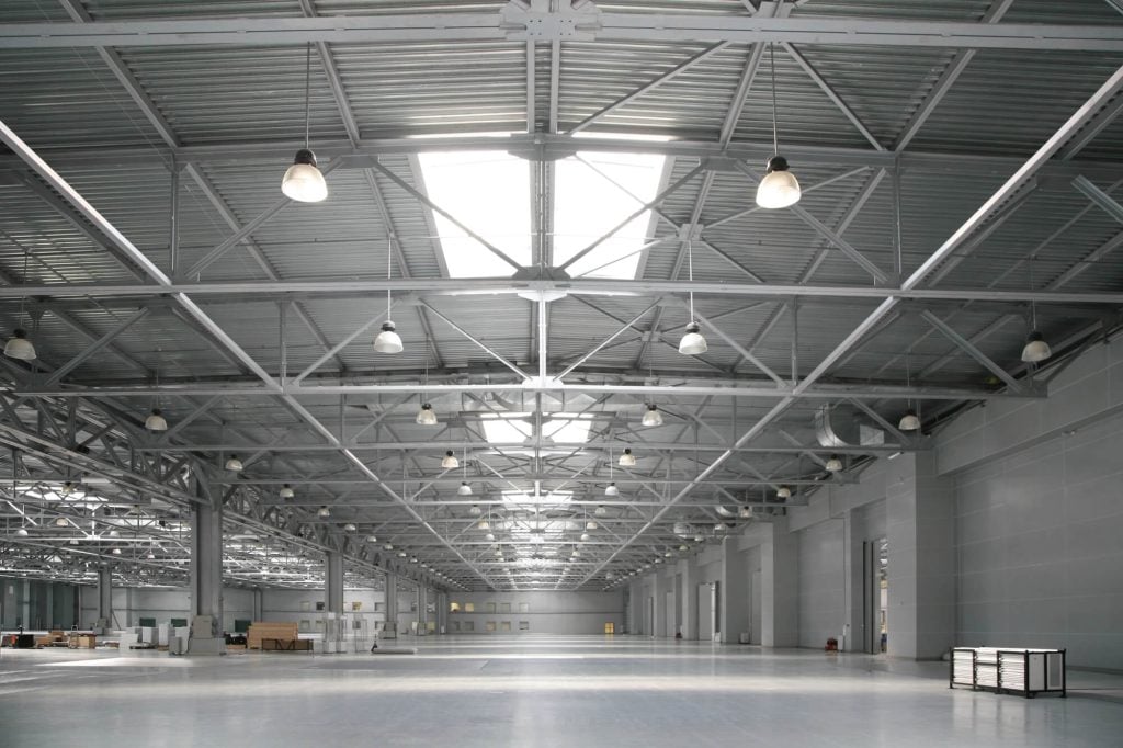 A warehouse with a tall ceiling and High Bay lights