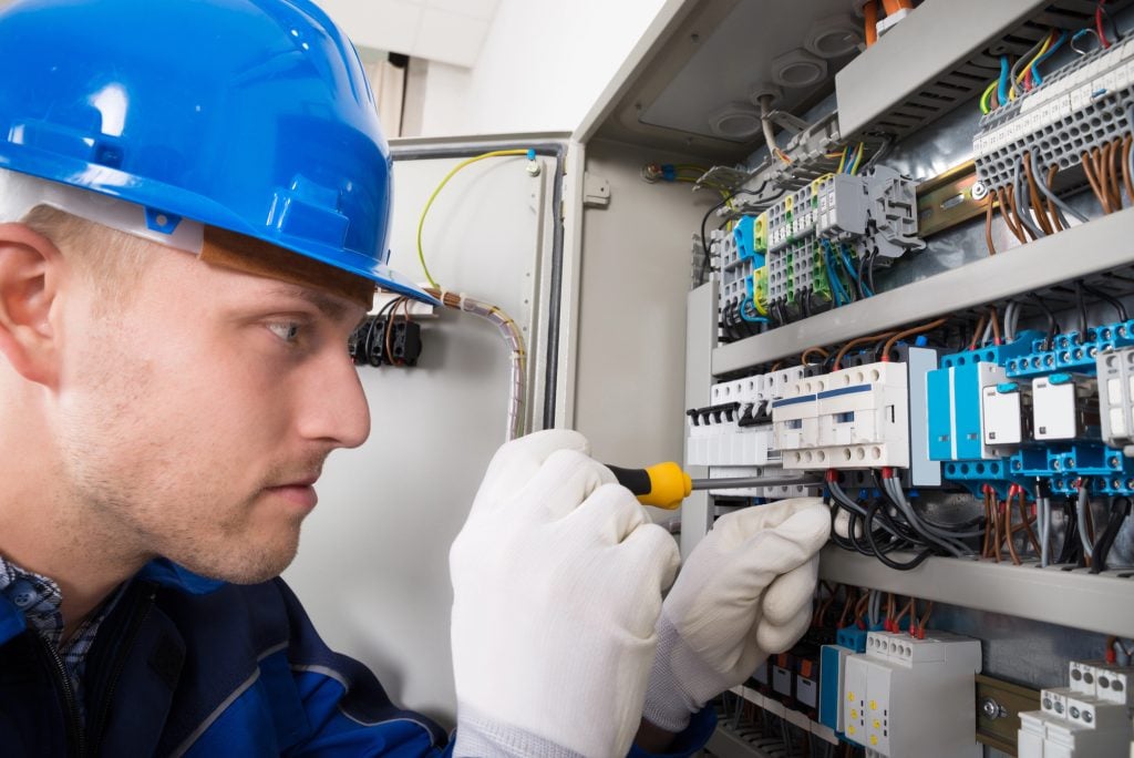 An electrician working on a circuit breaker